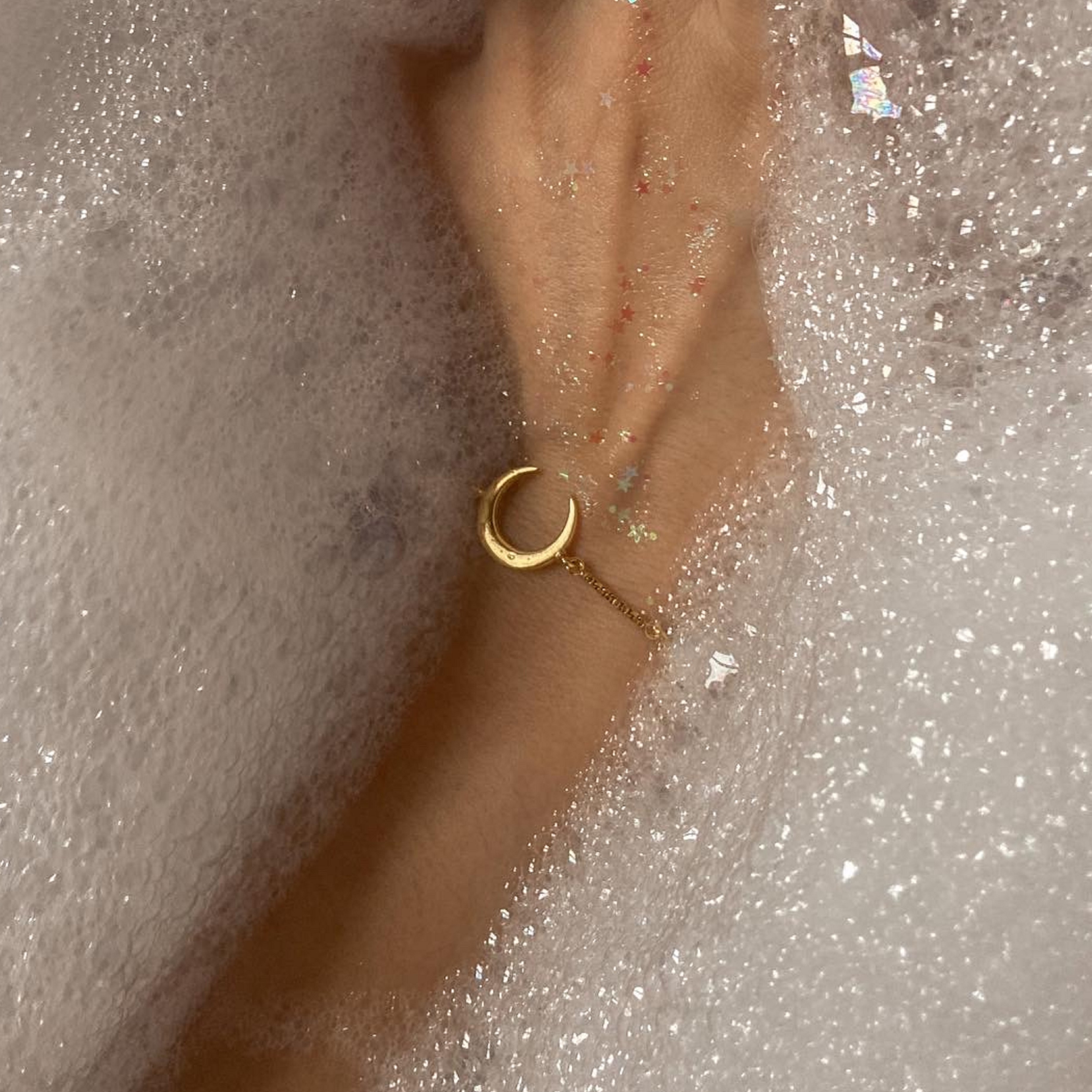 Gold bracelet with a thin gold chain and a moon charm