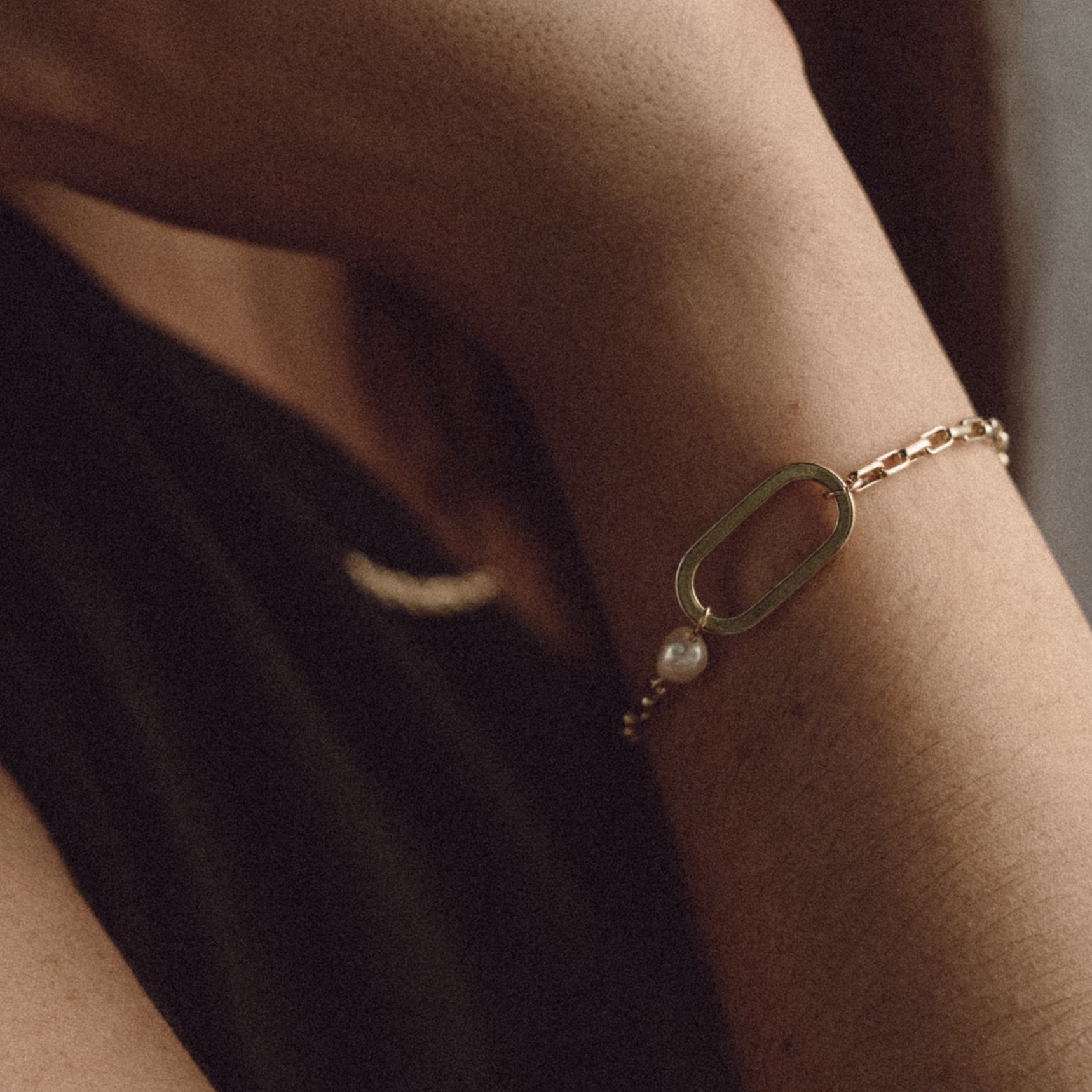 A gold bracelet with one oval charm