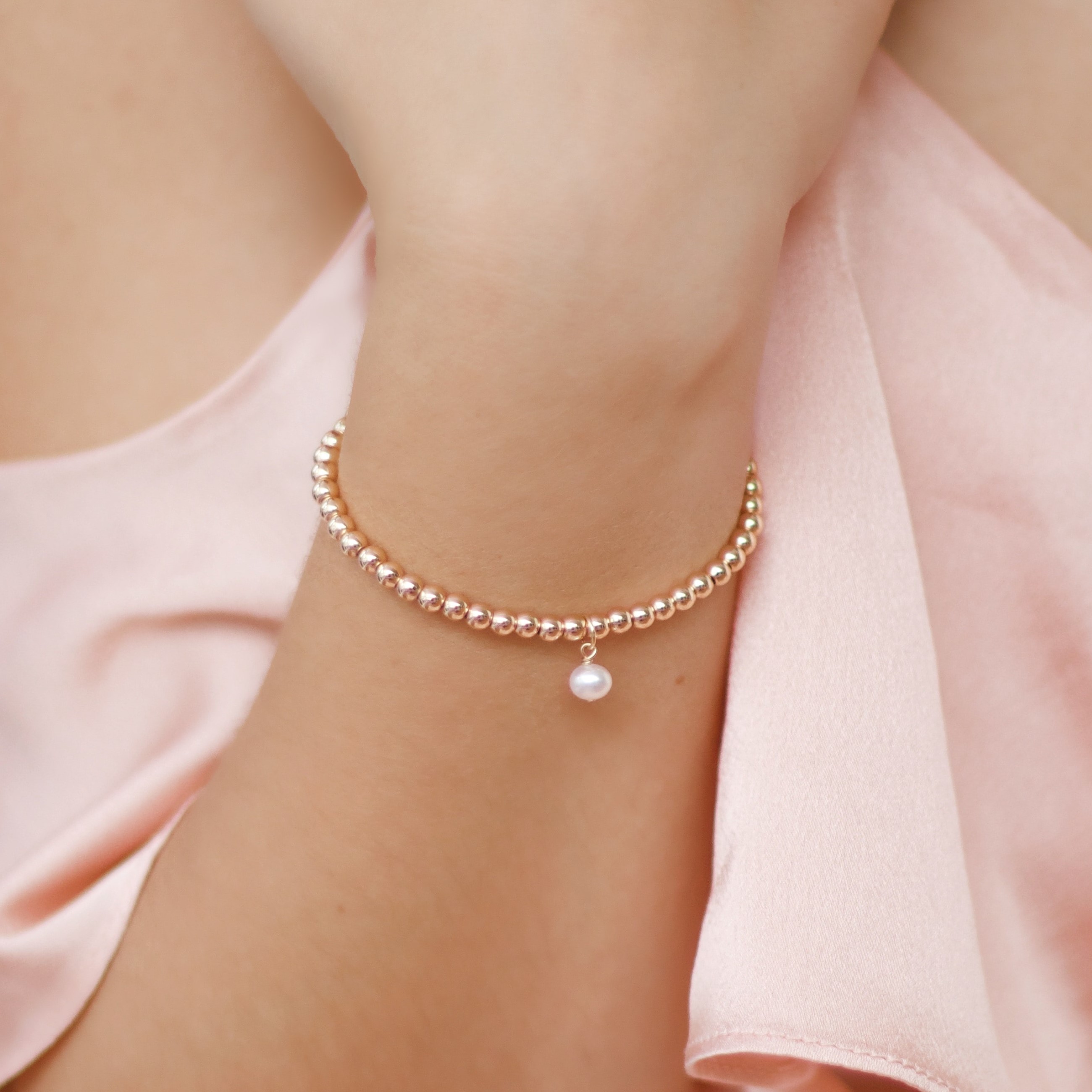 A pearl bracelet with one pearl charm