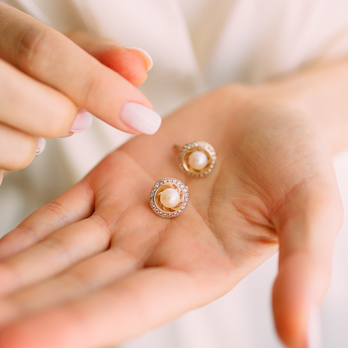 Tiny round earrings with central pearl and surroundind it diamonds