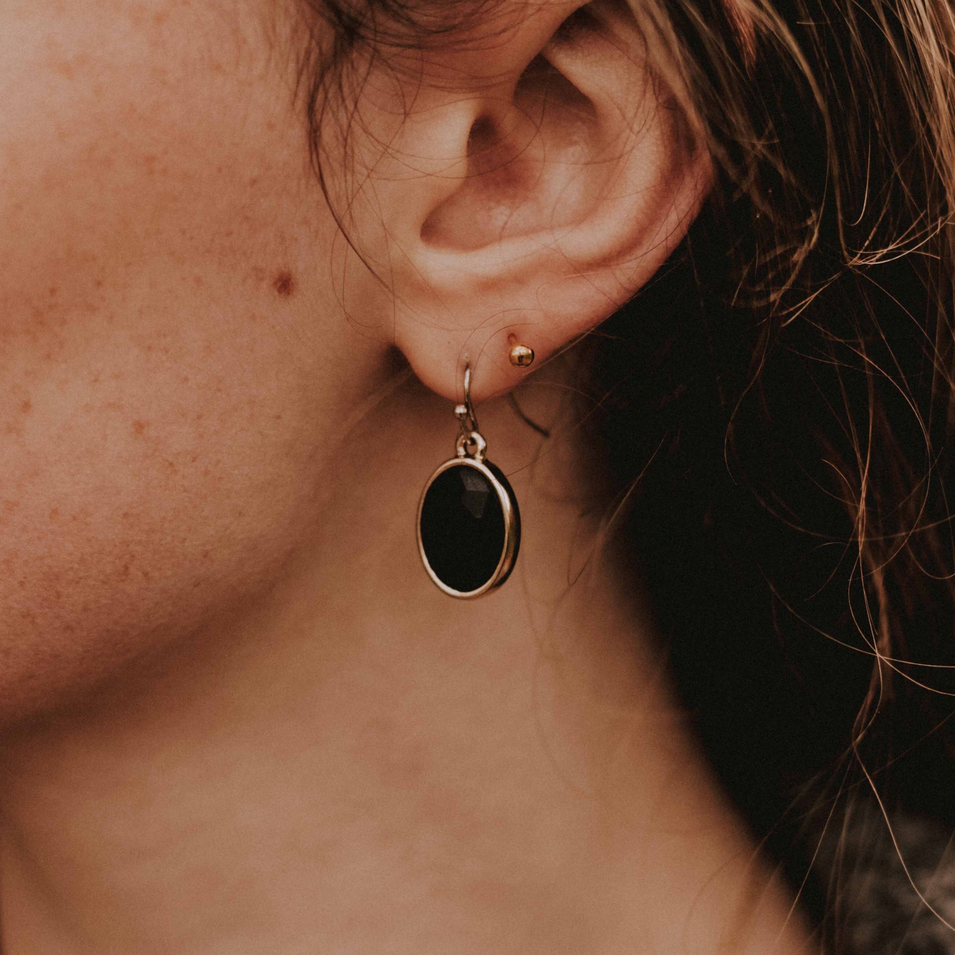 Black oval earrings in a golden frame