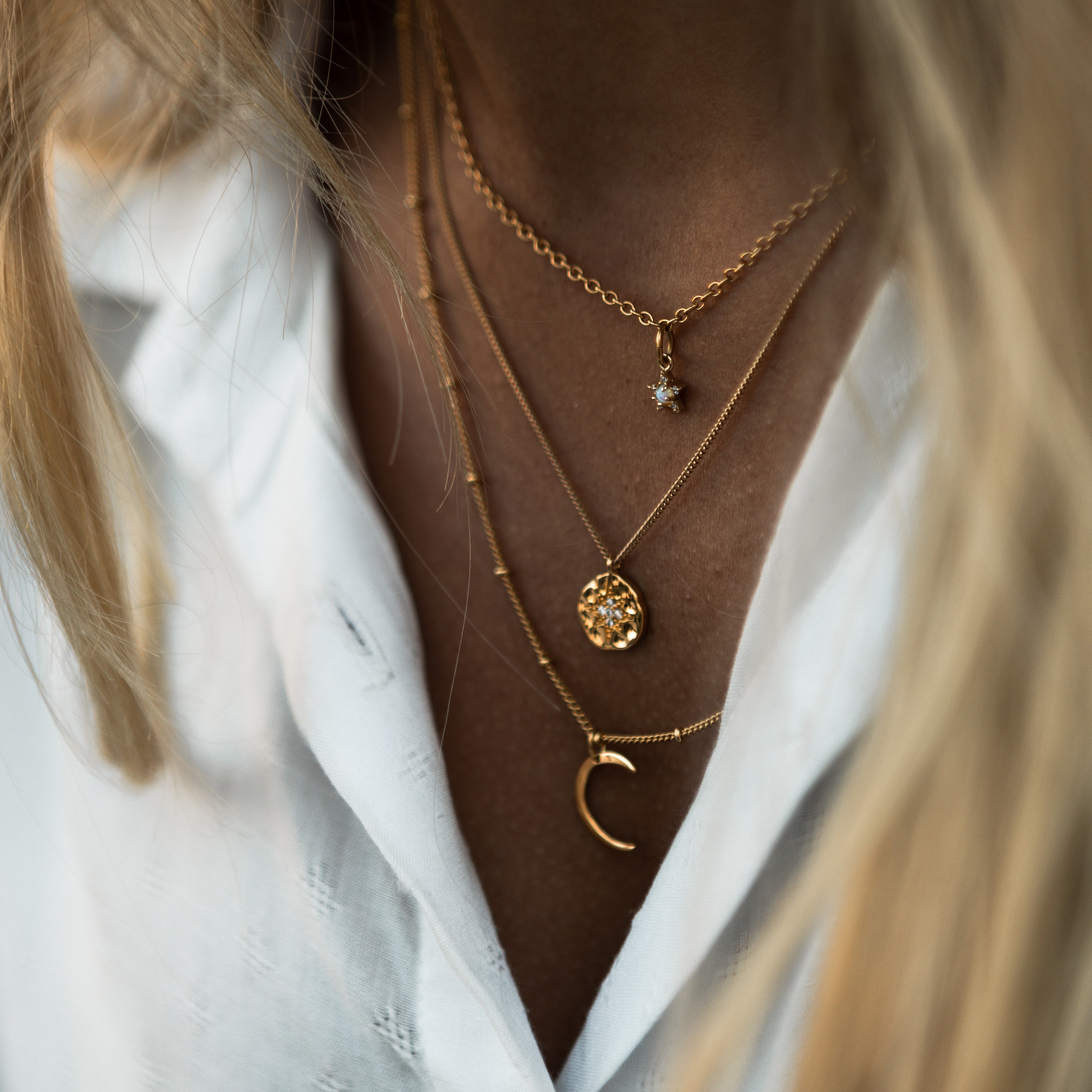A boho style gold necklace with many round golden charms