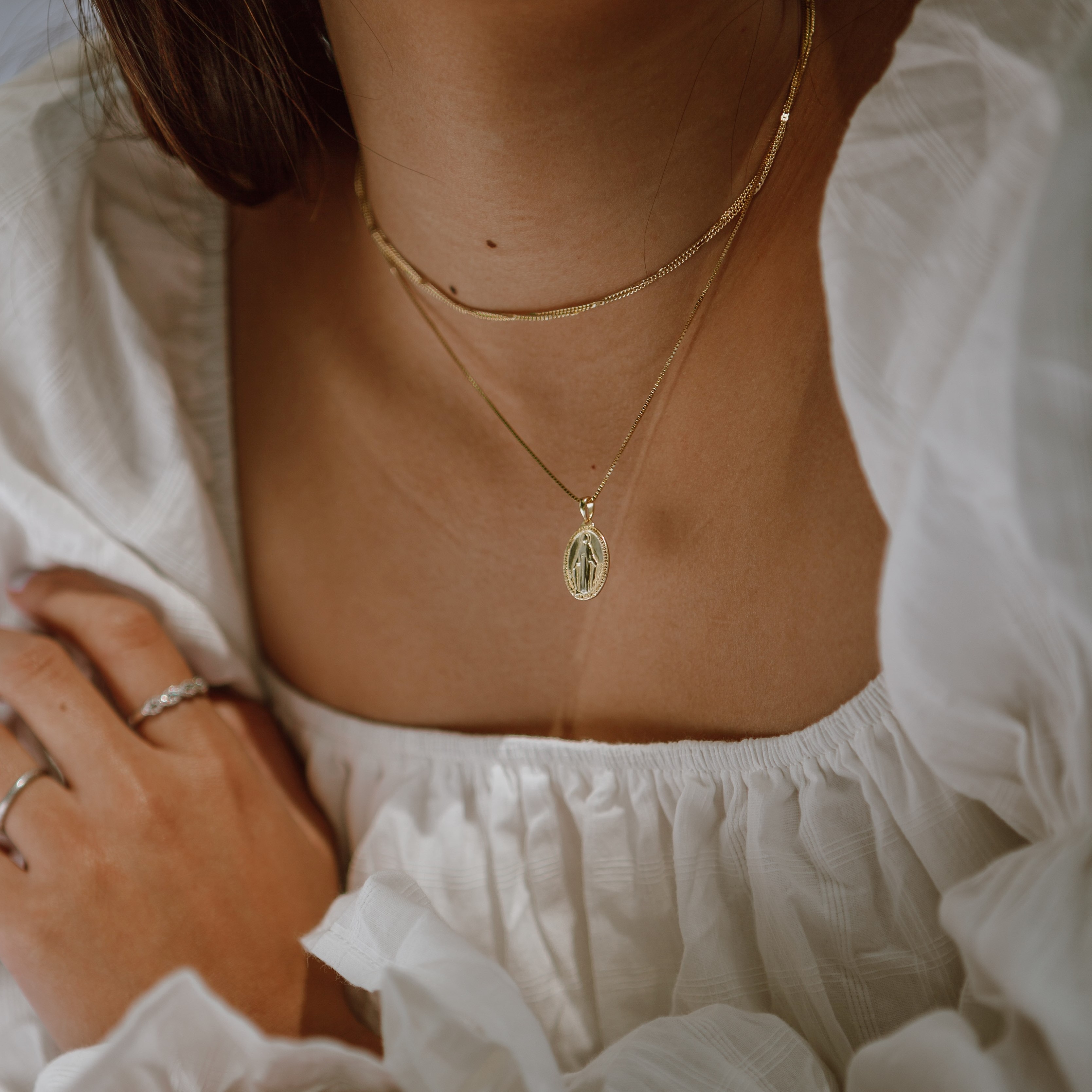 A minimalistic necklace with golden chain and one oval charm