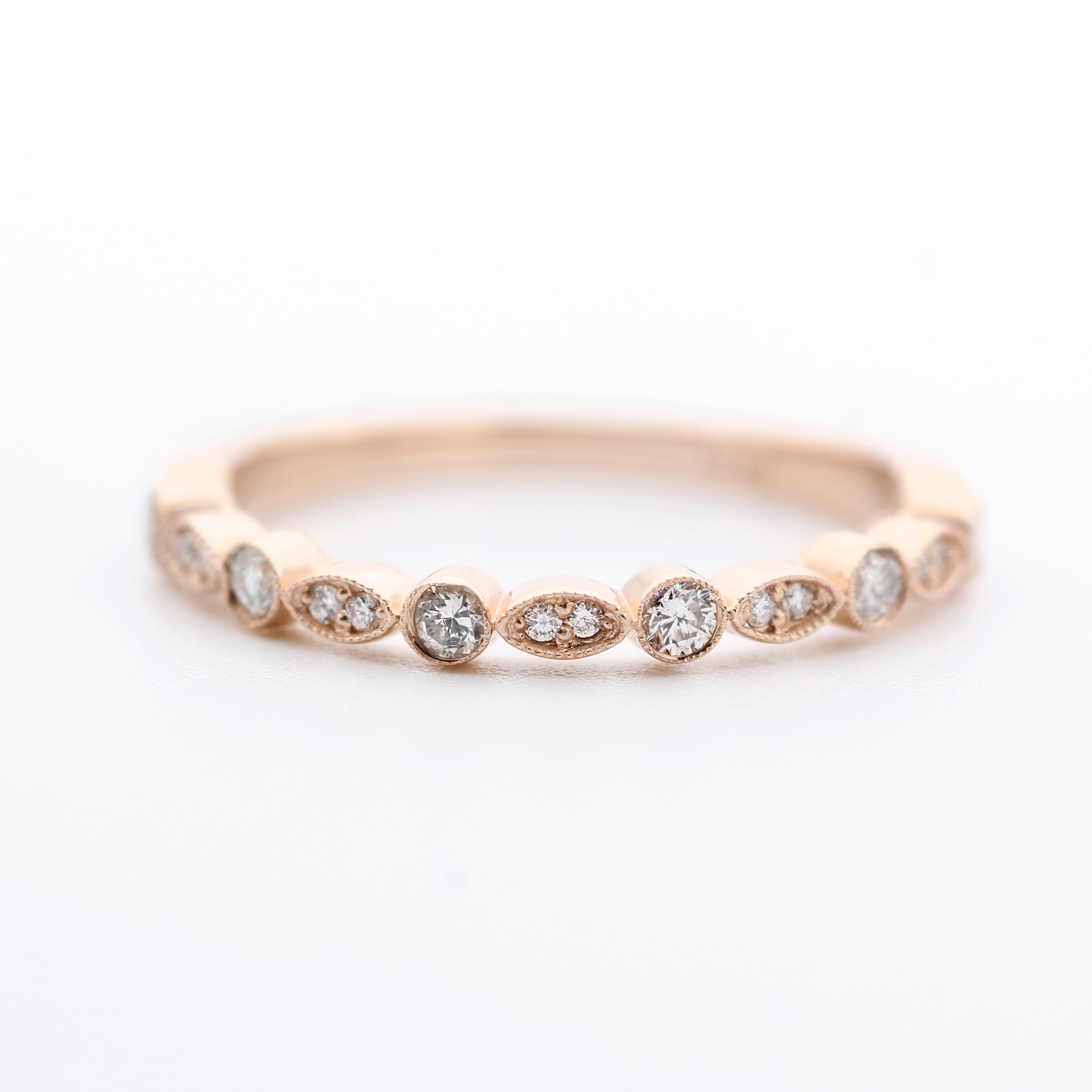 A rose gold ring with oval and round diamonds